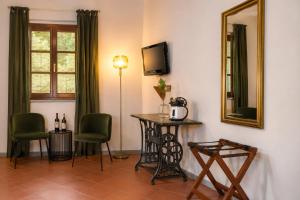 a room with a table and chairs and a mirror at Hotel Sor Paolo in San Casciano in Val di Pesa