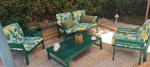 a patio with three chairs and a table and a couch at Gîte effet d’art in Saint-Privat