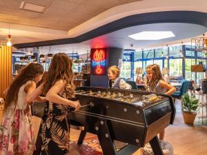 a group of people playing a game of foosball at Novotel La Rochelle Centre in La Rochelle