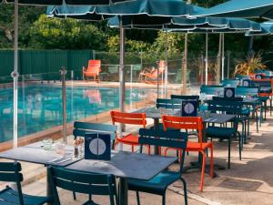 a row of tables and chairs next to a swimming pool at Novotel La Rochelle Centre in La Rochelle +167 photos