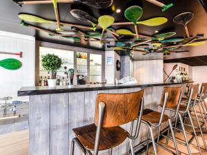 a bar with four chairs at a counter at ibis styles La Rochelle Thalasso Chatelaillon in Châtelaillon-Plage