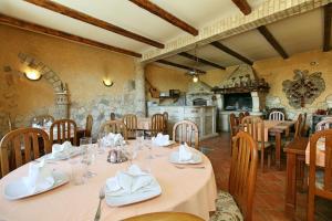 a dining room with tables and chairs and a kitchen at Sobe ROOMS TEA in Buje