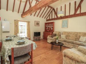 a living room with a table and a couch at Byre Cottage 3 in Pulborough