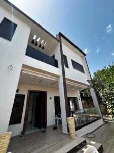 a large white house with a wooden deck at Villa Zahra in Bizerte