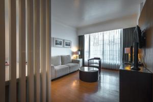 a living room with a couch and a table at HARRIS Hotel & Conventions Malang in Malang
