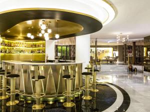 a lobby with a bar with stools at Sofitel Lisbon Liberdade in Lisbon