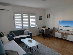 a living room with a couch and a tv and a table at Vitez apartman in Vitez