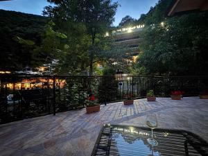 a balcony with a view of a building with wine glasses at Casa Crina in Băile Herculane
