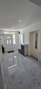 an empty room with white walls and concrete floors at Kuća za odmor BARSON in Vukovar