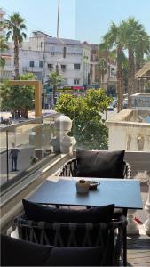 a table and chairs on a balcony with a view of a city at Zoe Boutique Hotel in Durrës