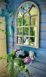 a window on a blue wall with flowers on it at La Porte Bleue le grenier des Anges in Saint-Pierre +13 photos