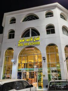 a building with two cars parked in front of it at فندق فاديه الذهبي in ‘Ushayrah