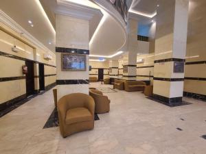a lobby with couches and chairs in a building at Qimmat AlAwali Hotel in Az Zahrāʼ
