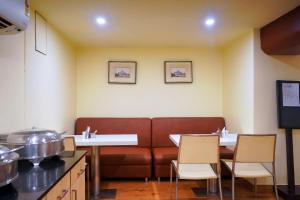 a waiting room with a couch in a restaurant at Middleton Inn in Kolkata