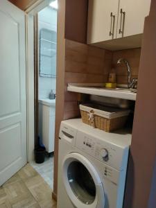 a kitchen with a washing machine and a sink at Apartman Petrov in Pančevo