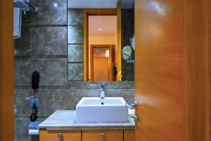 a bathroom with a sink and a mirror at Middleton Inn in Kolkata