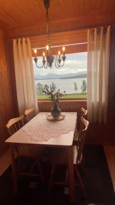 a dining room table with a vase on it and a window at Senja seaside retreat in Senja