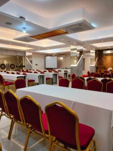 a conference room with white tables and chairs and a screen at Grand Khalifa Hotel Hamama in Sylhet +91 photos