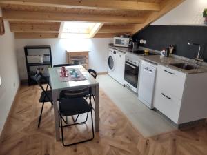 a kitchen with a table and a stove top oven at Vaniria 4 Apartamentos Nuevos in Foz