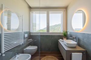 a bathroom with a sink and a toilet and two windows at The Circle Bike Residence by Rent All Como in Tavernerio +123 photos