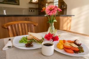 a table with two plates of food and a vase of flowers at Liam Private Villa in Ubud