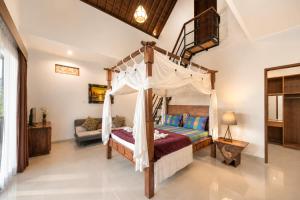 a bedroom with a canopy bed and a couch at Liam Private Villa in Ubud