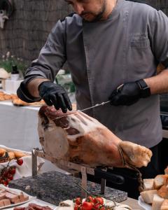 a man is preparing a turkey on a grill at Rouge International Resort in Milano Marittima