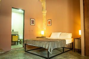 a bedroom with a bed in a room with orange walls at Capital O Adhoc Barrio Antiguo in Monterrey