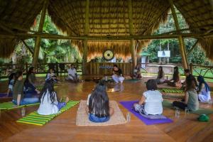Eine Gruppe von Menschen sitzt in einer Yogastunde. in der Unterkunft 2 Family Comfort Rooms with Terrace - Luna Tierra in Cumaral