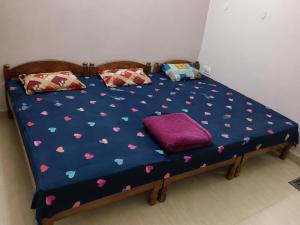 a bed with a blue comforter with hearts on it at Siddhi palace in Maihar