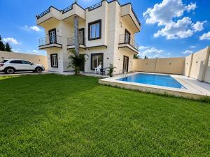 a house with a swimming pool in the yard at La Dolce Villa with Private Pool in Borg El Arab