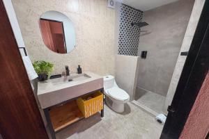 a bathroom with a sink and a toilet and a mirror at Capital O Adhoc Barrio Antiguo in Monterrey
