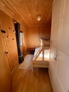 a room with a bed in a wooden cabin at Senja seaside retreat in Senja