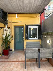 a patio with two chairs and a table and a door at Alla Chiesetta in Naples