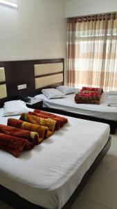 zwei Betten in einem Zimmer mit Handtüchern darauf in der Unterkunft Well Park Resort in Cox's Bazar