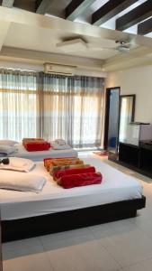 ein Schlafzimmer mit drei Betten mit roten Kissen in der Unterkunft Well Park Resort in Cox's Bazar + 11 Fotos
