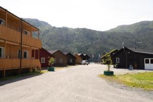 a group of houses with mountains in the background at Standard Rom in Fjæra