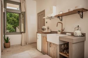 a kitchen with a sink and a window at JUNO Collection Residences in Pythagoreio +80 photos