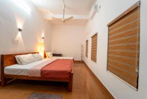 a bedroom with a bed with a wooden door at Chandralayam Heritage Homestay in Bekal