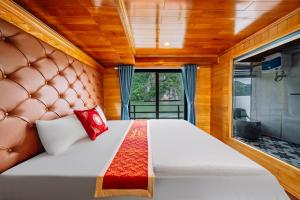 a bedroom with a large bed with a large window at Vietnam Venture Cruises in Cat Ba