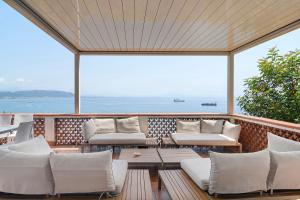 a balcony with white couches and a view of the ocean at Villa Fuenti Bay - Amalfi Coast in Cetara