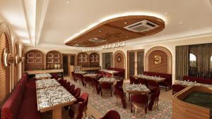 a restaurant with tables and chairs in a room at Avsar Resort in Verāval