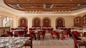 a restaurant with tables and chairs in a room at Avsar Resort in Verāval