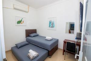 a small room with two beds and a desk at Lestari Malioboro Guesthouse in Sentool