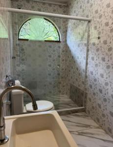 a bathroom with a sink and a shower with a window at Alto Paraiso in Teresópolis +32 photos