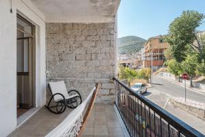 a bench on a balcony with a view of a street at Ammentos La Casa di Rosa in Orgosolo