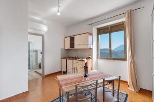 a kitchen and dining room with a table and chairs at Ammentos La Casa di Rosa in Orgosolo +65 photos