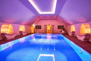 a swimming pool in a house with purple lighting at Hotel Taschenbergpalais Kempinski in Dresden