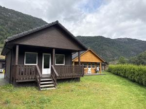a small house with a porch and a house at Standard Hytte in Fjæra