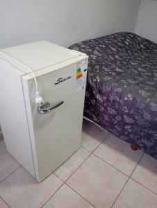 a small refrigerator in a room with a bed at Habitación loft centrica in Esperanza